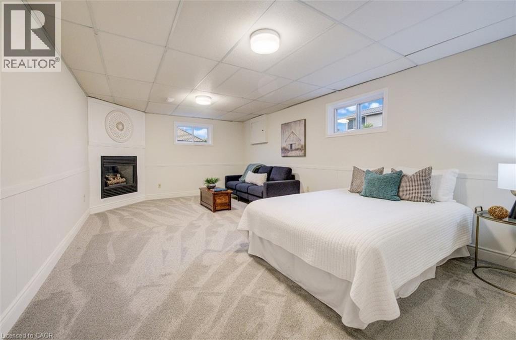 Basement 4th bedroom with lounge area and gas fireplace, a perfect spot for a teenager or in-law suite. - 66 Tupper Crescent, Kitchener, ON - Indoor Photo Showing Bedroom