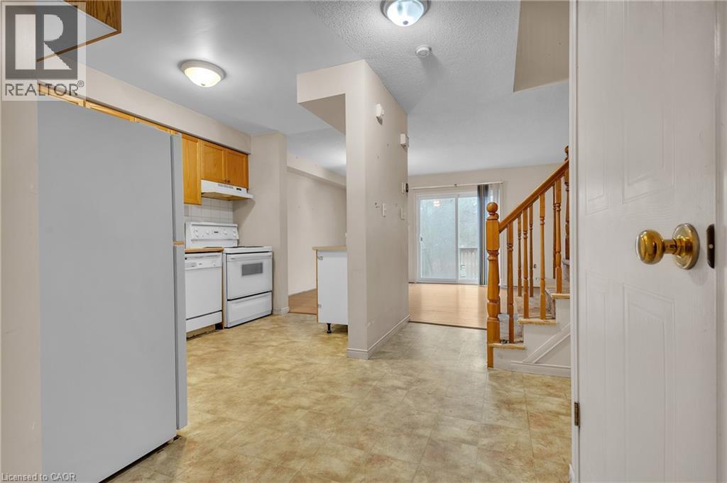 Kitchen featuring white appliances, light countertops, and a textured ceiling - 26 Roehampton Crescent, Guelph, ON - Indoor Photo Showing Other Room