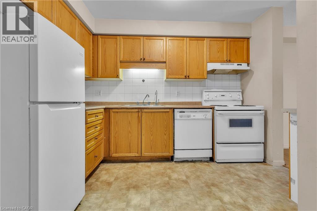 Kitchen with white appliances, light countertops, backsplash, and wood finish cabinets - 26 Roehampton Crescent, Guelph, ON - Indoor Photo Showing Kitchen