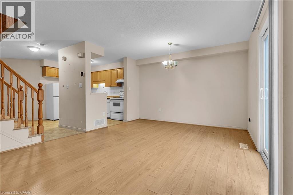 Unfurnished living room with suspended lighting and light wood-style flooring - 26 Roehampton Crescent, Guelph, ON - Indoor Photo Showing Other Room