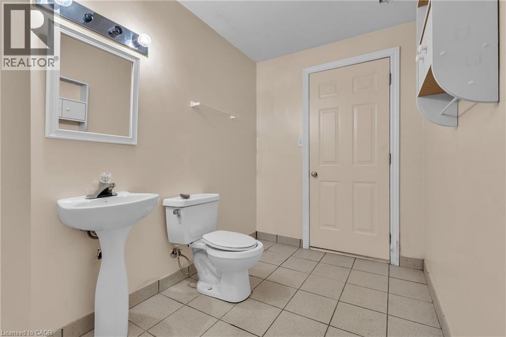 Half bathroom featuring toilet and light tile patterned floors - 26 Roehampton Crescent, Guelph, ON - Indoor Photo Showing Bathroom