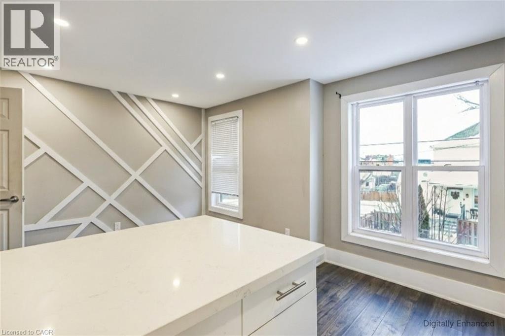 Kitchen featuring dark wood-style flooring, plenty of natural light, recessed lighting, light stone counters, and white cabinets - 27 Ashley Street, Hamilton, ON - Indoor Photo Showing Other Room