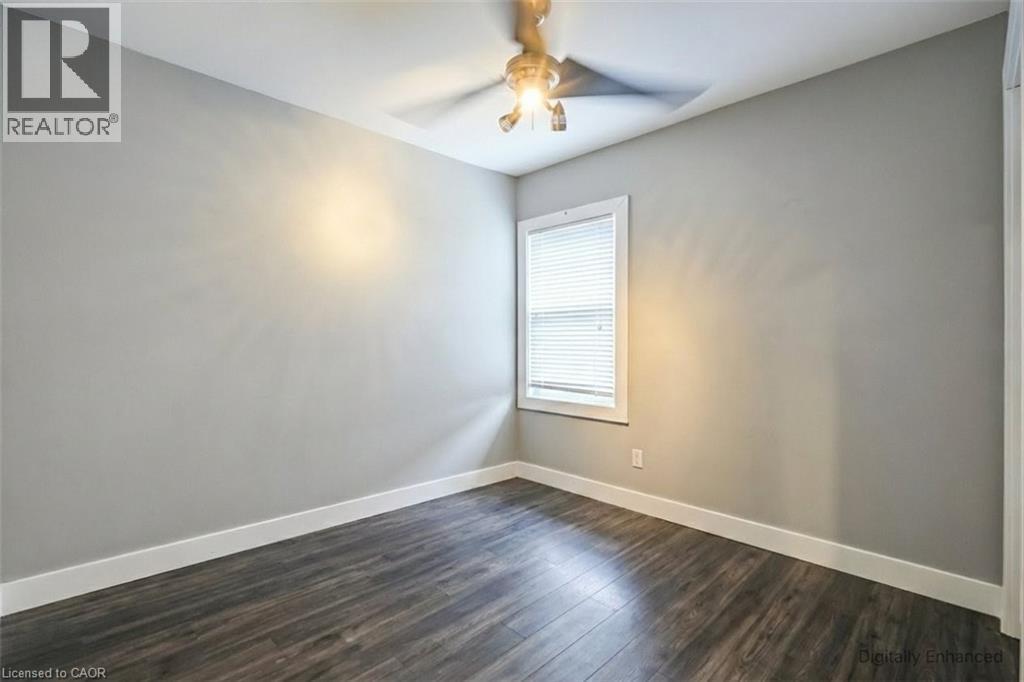 Unfurnished room with dark wood-style floors and a ceiling fan - 27 Ashley Street, Hamilton, ON - Indoor Photo Showing Other Room