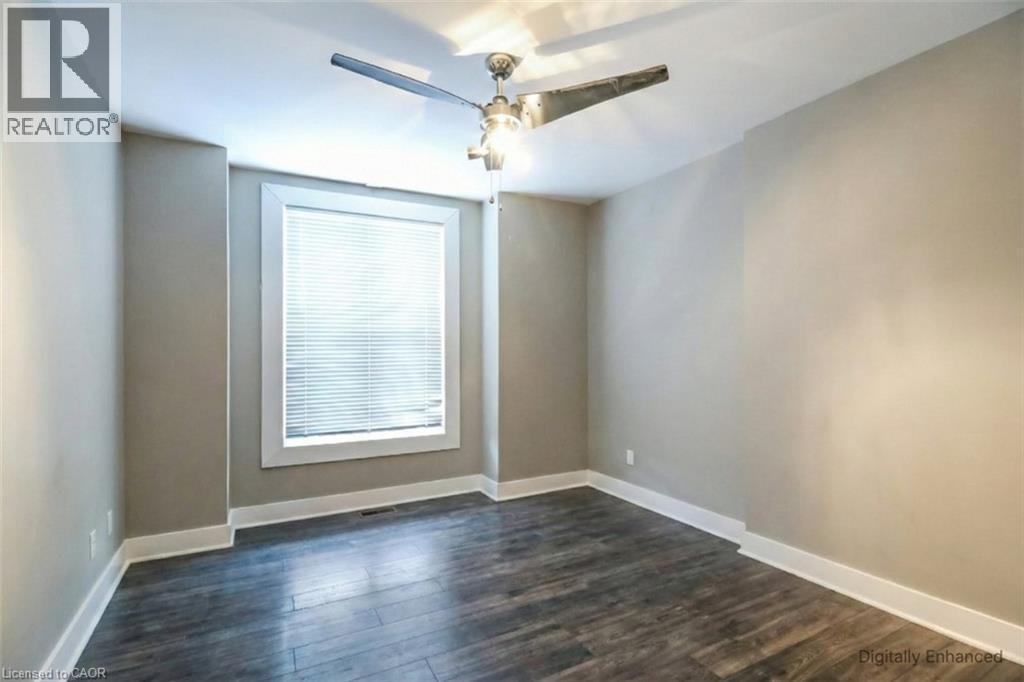 Empty room with dark wood finished floors and a ceiling fan - 27 Ashley Street, Hamilton, ON - Indoor Photo Showing Other Room