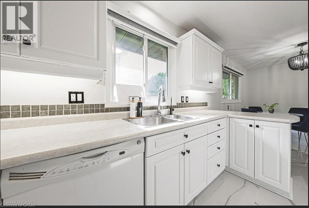 Kitchen featuring dishwasher, a peninsula, light countertops, white cabinetry, and light marble finish floors - 267 Erb Street E, Waterloo, ON - Indoor Photo Showing Kitchen