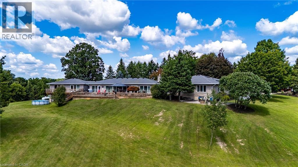 Rear view of property featuring a lawn and a wooden deck - 1285 Cockshutt Road, Simcoe, ON - Outdoor