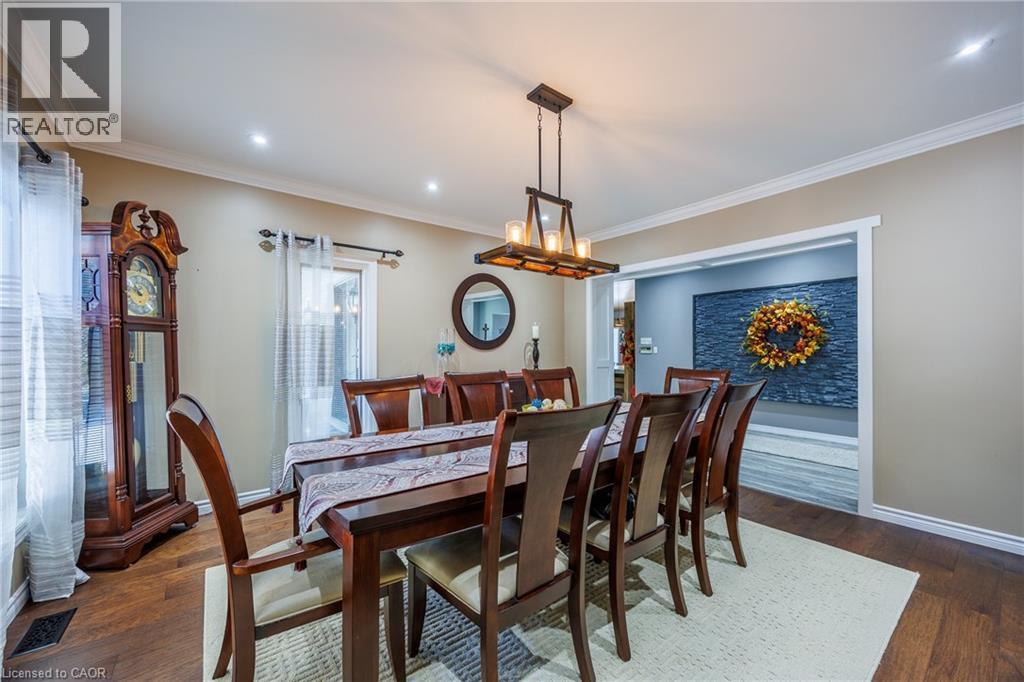 Dining area featuring dark wood-style floors, crown molding, and suspended lighting - 1285 Cockshutt Road, Simcoe, ON - Indoor Photo Showing Dining Room