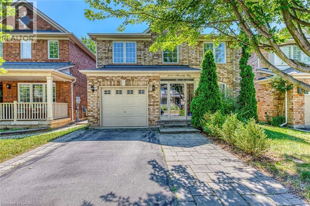 View of front of house with asphalt driveway, an attached garage, a porch, and brick siding - 3037 Abernathy Way, Oakville, ON - Outdoor