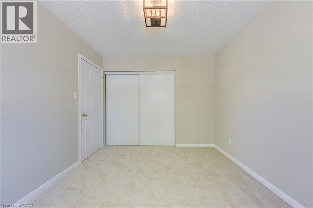 Bedroom 4 with light carpet, a closet, and a textured ceiling - 3037 Abernathy Way, Oakville, ON - Indoor Photo Showing Other Room