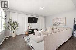 Living area with dark wood-style flooring and baseboards -
