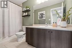Full bath featuring vanity and shower / bathtub combination with curtain -