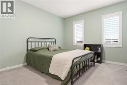 Bedroom featuring light colored carpet and baseboards -