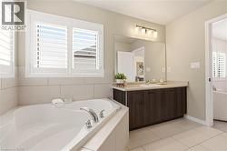 Full bathroom featuring a bath, vanity, and light tile patterned flooring -