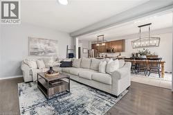Living room featuring suspended lighting and wood finished floors -