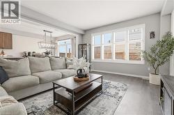 Living room featuring wood finished floors and hanging lights -