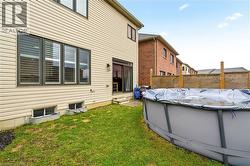 Rear view of property featuring a covered pool and entry steps -