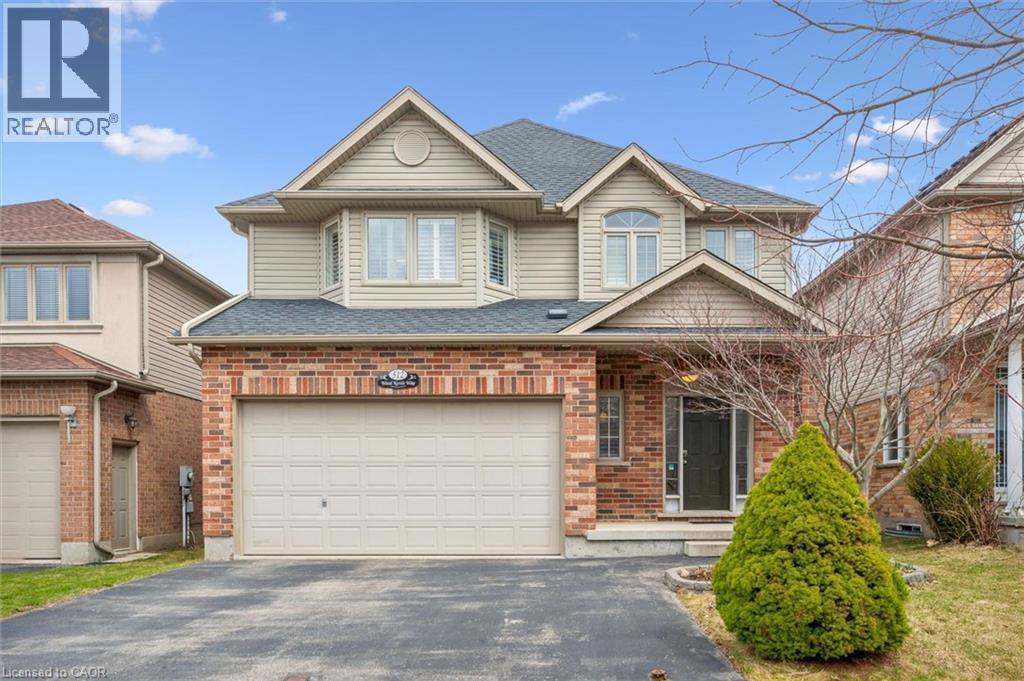 View of front of home with driveway, brick siding, and roof with shingles - 512 Wood Nettle Way, Waterloo, ON - Outdoor With Facade
