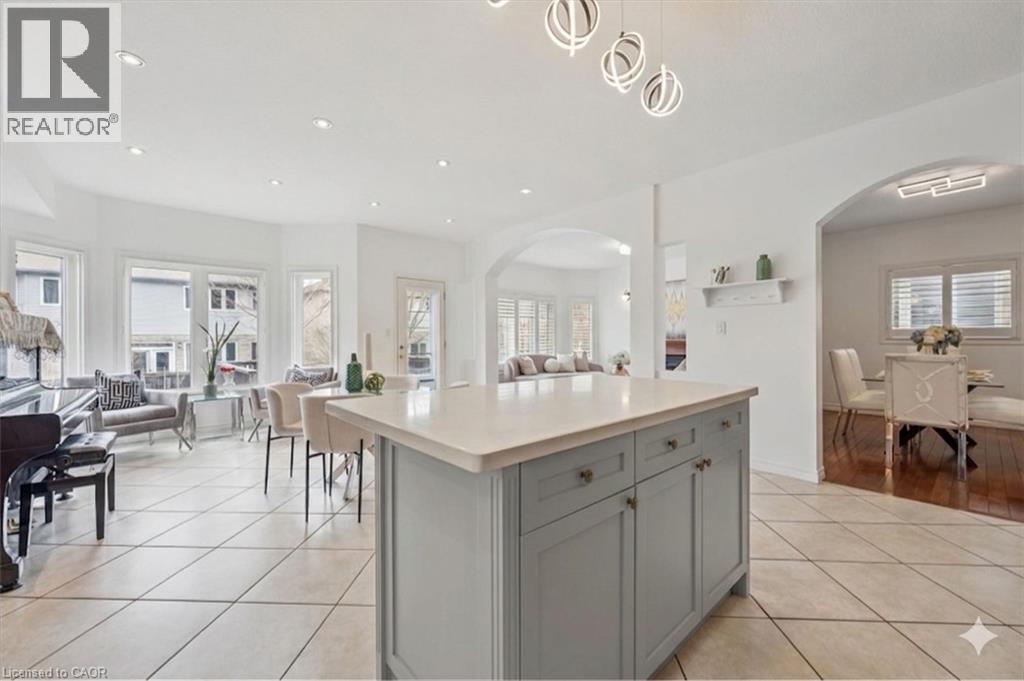 Kitchen island featuring a light-colored countertop and grey cabinetry with brass hardware - 512 Wood Nettle Way, Waterloo, ON - Indoor Photo Showing Other Room