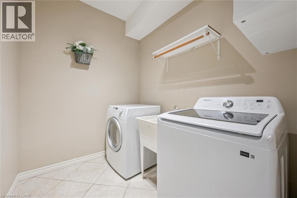 Laundry room with washing machine and clothes dryer and light tile patterned floors - 512 Wood Nettle Way, Waterloo, ON - Indoor Photo Showing Laundry Room