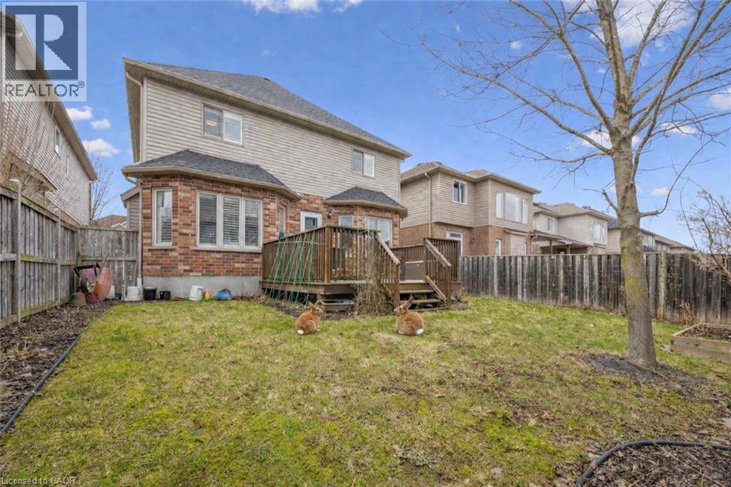 Back of property with brick siding, a wooden deck, and a fenced backyard - 512 Wood Nettle Way, Waterloo, ON - Outdoor