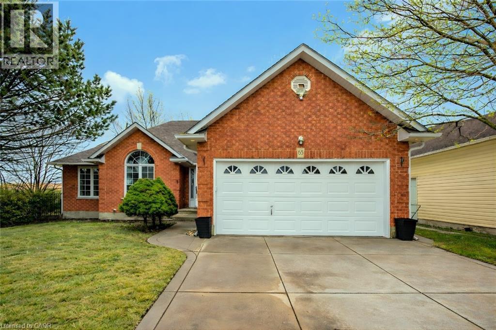 View of front of home featuring brick siding, concrete driveway, a garage, and a front yard - 65 Thistlemoor Drive, Caledonia, ON - Outdoor