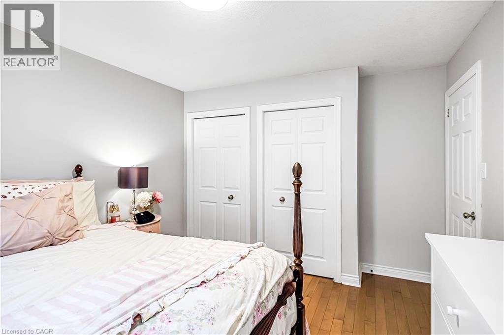 Bedroom featuring two closets and dark wood-type flooring - 65 Thistlemoor Drive, Caledonia, ON - Indoor Photo Showing Bedroom