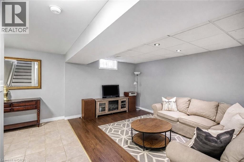 Living room featuring light wood finished floors and a drop ceiling - 65 Thistlemoor Drive, Caledonia, ON - Indoor