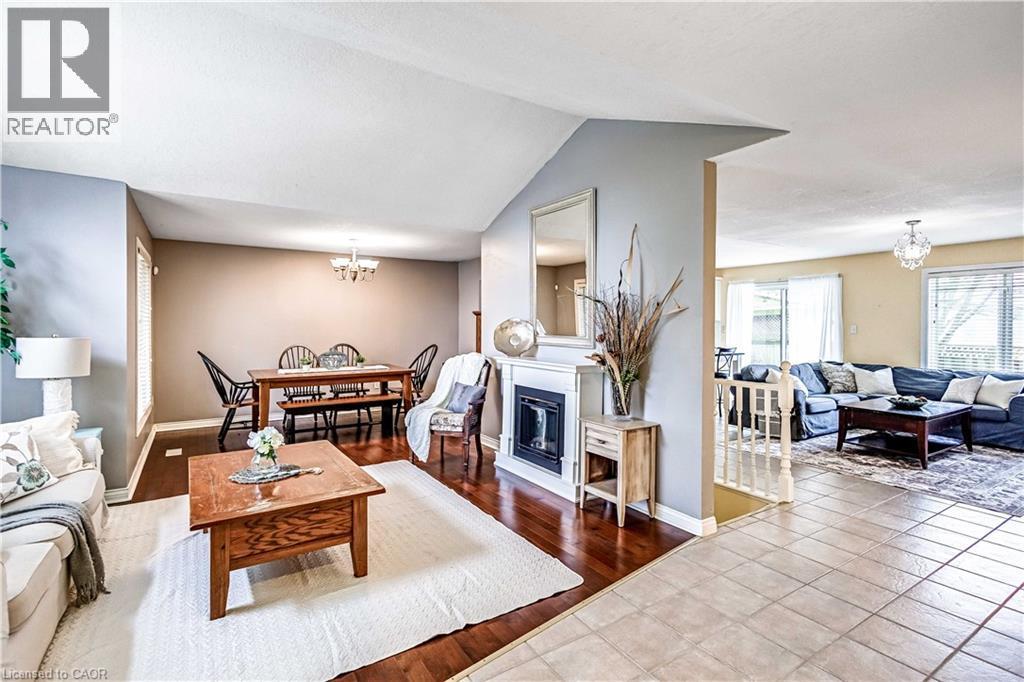 Tiled living room with hanging lights, a glass covered fireplace, and vaulted ceiling - 65 Thistlemoor Drive, Caledonia, ON - Indoor Photo Showing Living Room With Fireplace