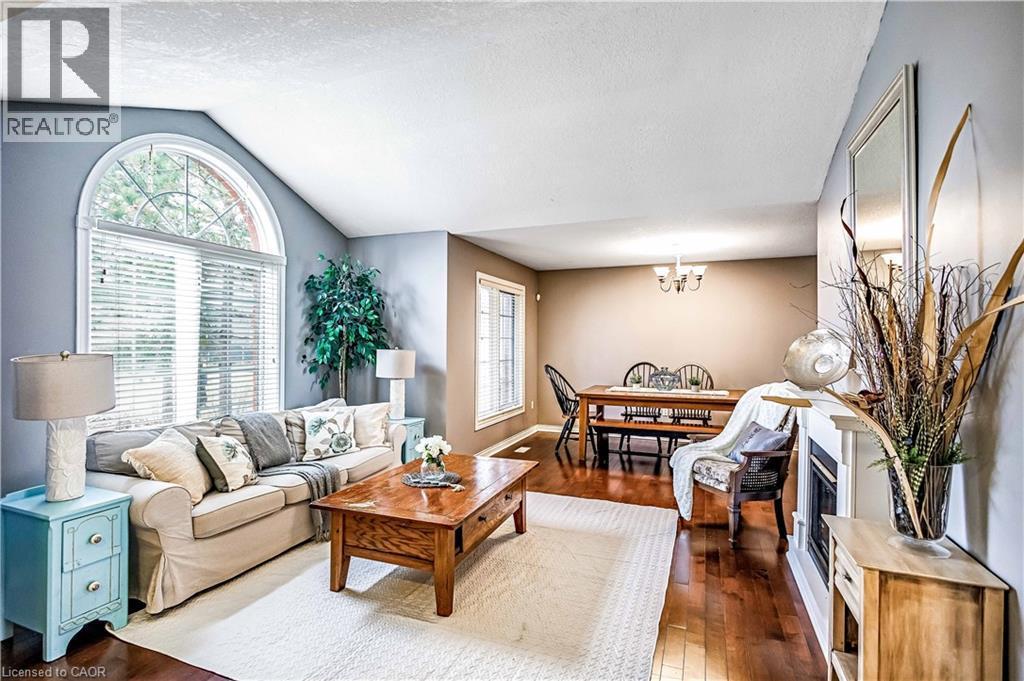 Living area featuring dark wood-style floors and a chandelier - 65 Thistlemoor Drive, Caledonia, ON - Indoor Photo Showing Living Room