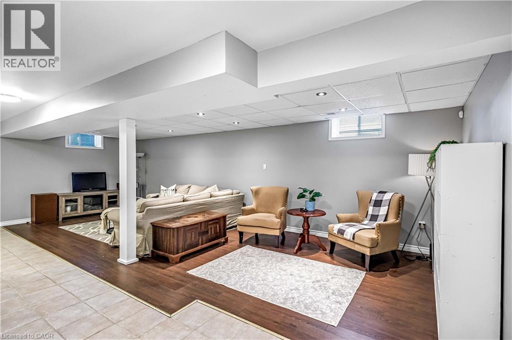 Living room featuring a drop ceiling and wood finished floors - 65 Thistlemoor Drive, Caledonia, ON - Indoor Photo Showing Basement