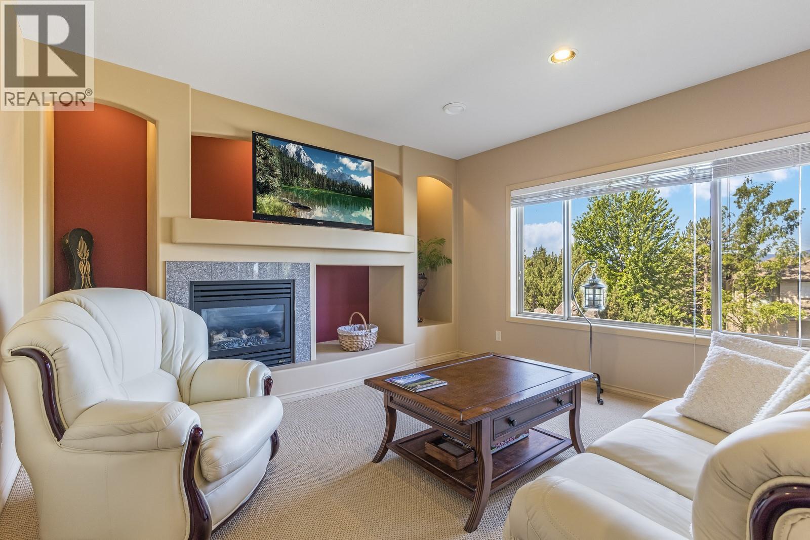 Lower level family room - 610 Arrowleaf Lane, Kelowna, BC - Indoor Photo Showing Living Room With Fireplace