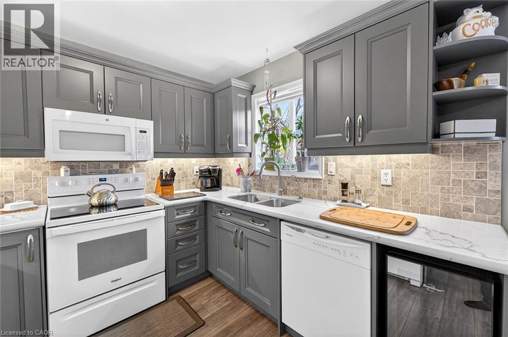 Kitchen featuring white appliances, gray cabinetry, open shelves, dark wood-style flooring, and light stone counters - 3753 Densbury Drive, Mississauga, ON - Indoor Photo Showing Kitchen With Double Sink
