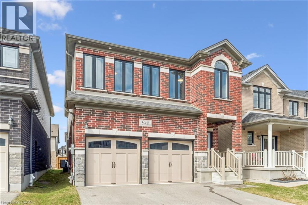 View of front of house with brick siding, a porch, an attached garage, and driveway - 628 Florencedale Crescent, Kitchener, ON - Outdoor With Facade