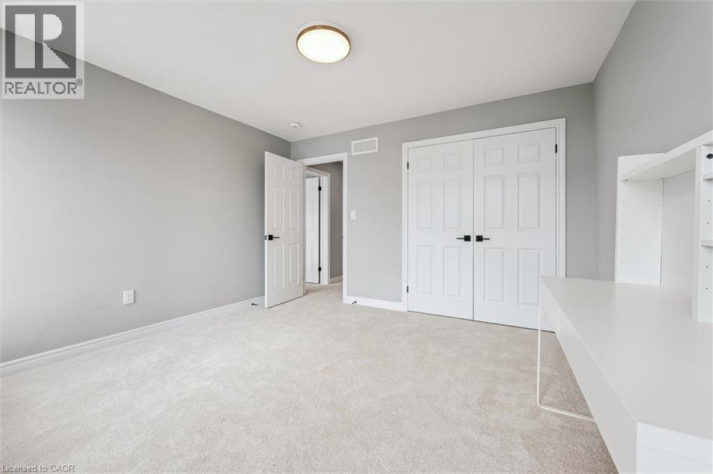 Unfurnished bedroom featuring light carpet and a closet - 628 Florencedale Crescent, Kitchener, ON - Indoor Photo Showing Other Room