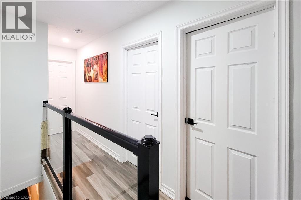Hallway with an upstairs landing and light wood-style flooring - 97 Keith Street, Hamilton, ON - Indoor Photo Showing Other Room