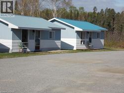 Ranch-style home with a metal roof and a porch -