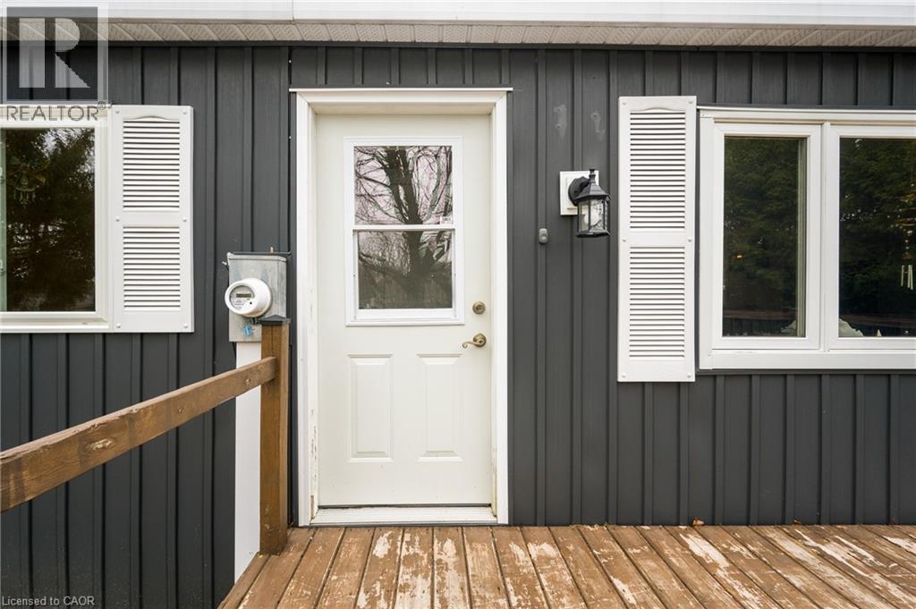 Property entrance featuring board and batten siding and a wooden deck - 157 Maple Crescent, Hamilton, ON - Outdoor With Exterior