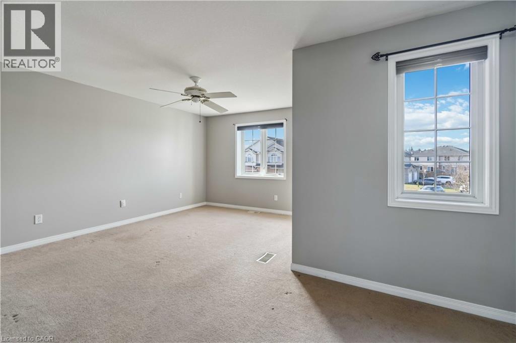 Empty room featuring light colored carpet and ceiling fan - 27 Red Clover Crescent, Kitchener, ON - Indoor Photo Showing Other Room