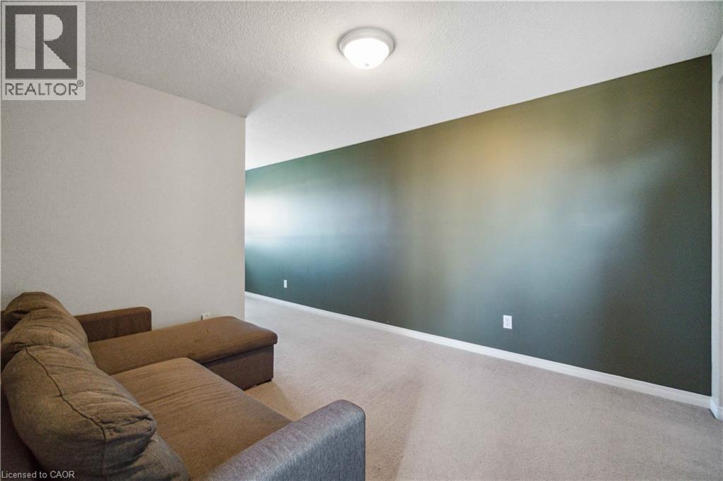 Carpeted living area featuring a textured ceiling and baseboards - 27 Red Clover Crescent, Kitchener, ON - Indoor Photo Showing Other Room
