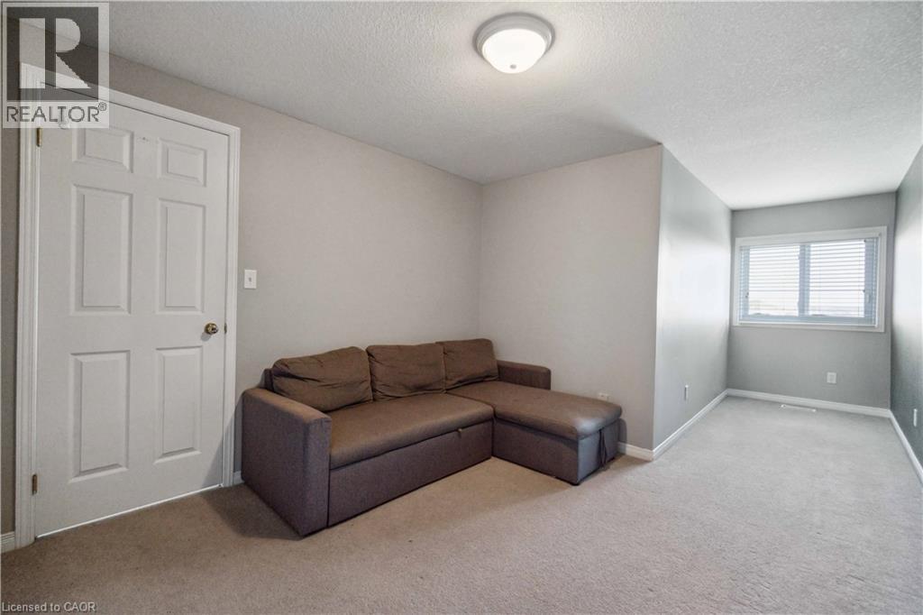 Living room with light carpet and a textured ceiling - 27 Red Clover Crescent, Kitchener, ON - Indoor