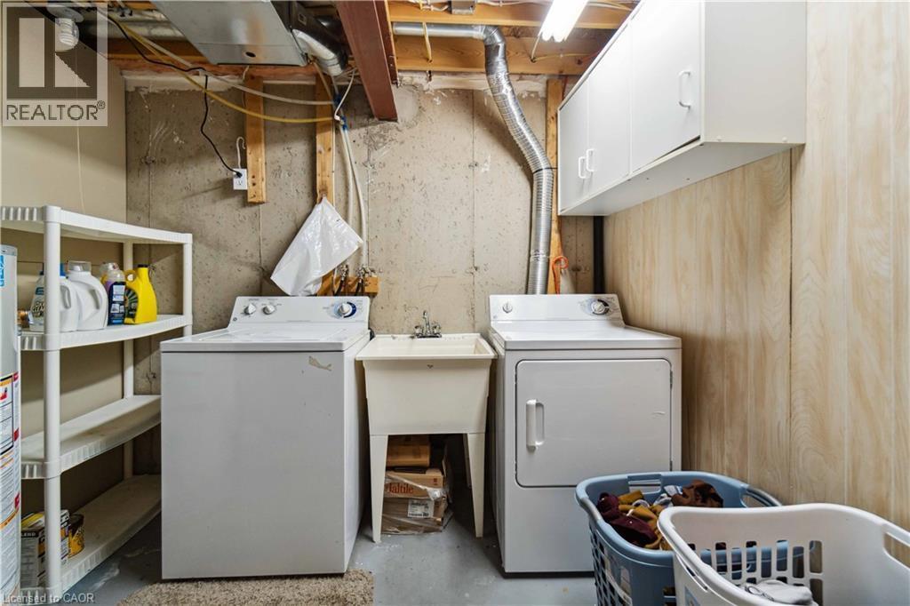 Laundry area with concrete flooring, washer and dryer, and cabinet space - 27 Red Clover Crescent, Kitchener, ON - Indoor Photo Showing Laundry Room
