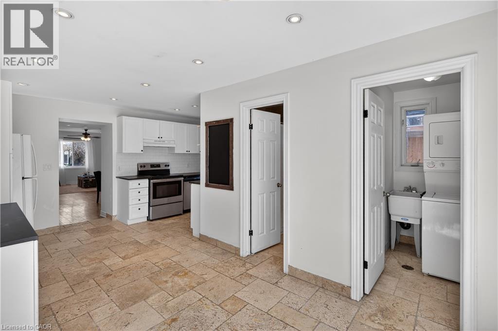 Kitchen with white cabinetry, stainless steel electric range, stone tile flooring, dark countertops, and recessed lighting - 216 Robert Street, Hamilton, ON - Indoor Photo Showing Kitchen