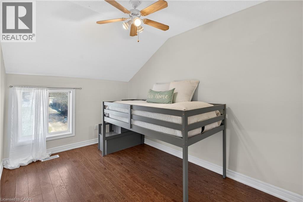 Bedroom with vaulted ceiling, dark wood-style floors, and a ceiling fan - 216 Robert Street, Hamilton, ON - Indoor