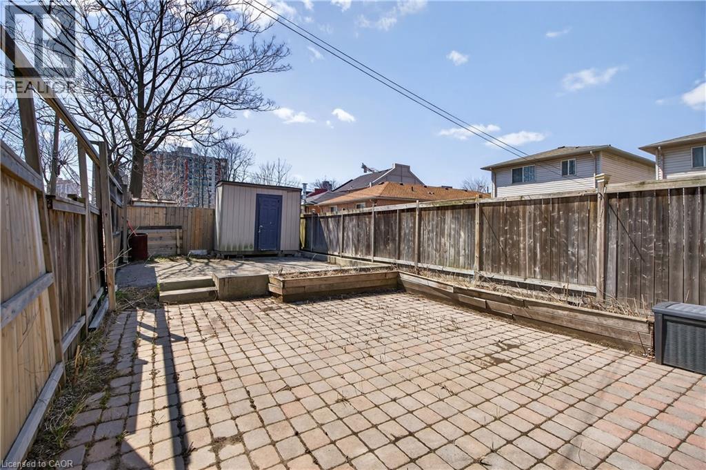 Fenced backyard featuring a storage unit and a patio - 216 Robert Street, Hamilton, ON - Outdoor With Deck Patio Veranda