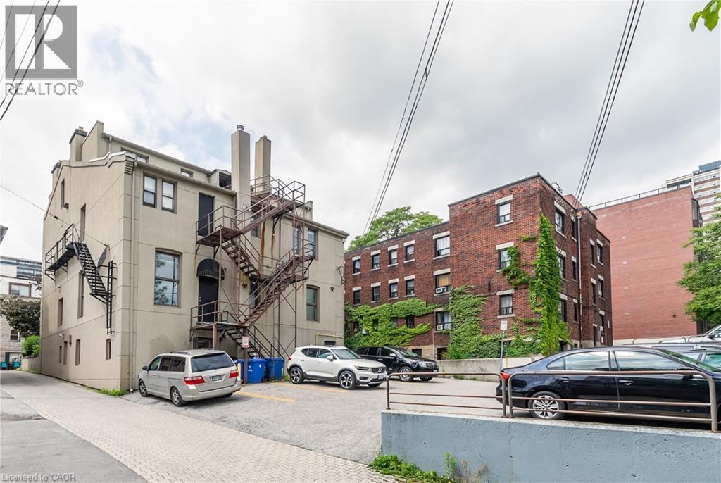 View of apartment building / complex with uncovered parking and stairs - 14 Duke Street, Hamilton, ON - Outdoor