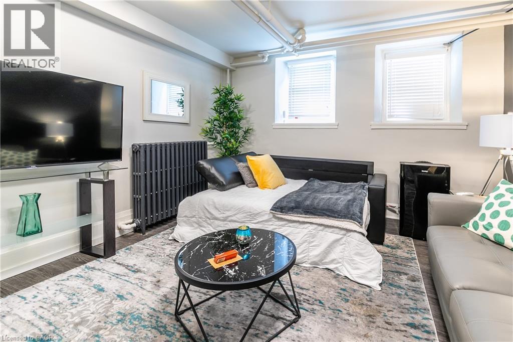 Bedroom with radiator and dark wood-style floors - 14 Duke Street, Hamilton, ON - Indoor Photo Showing Bedroom