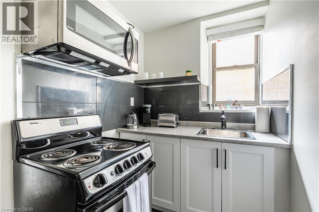 Kitchen with stainless steel appliances, white cabinetry, and light countertops - 14 Duke Street, Hamilton, ON - Indoor Photo Showing Kitchen