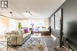 Living room featuring a barn door, a textured ceiling, and wood finished floors -