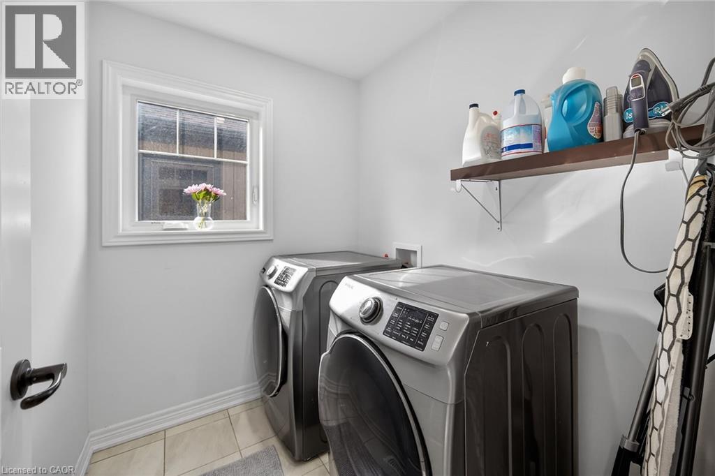 Laundry area with washing machine and dryer and light tile patterned floors - 80 Severino Circle, Smithville, ON - Indoor Photo Showing Laundry Room