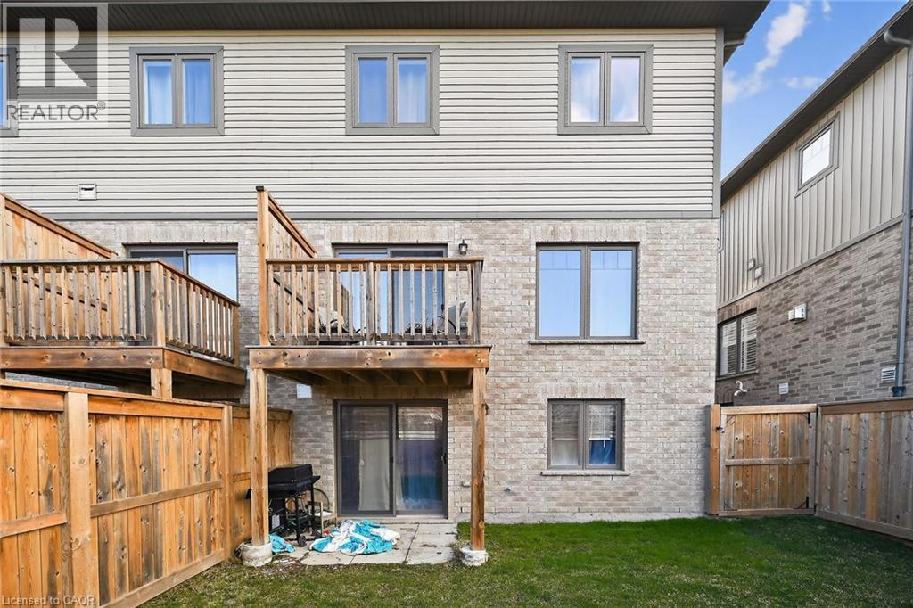 Rear view of house featuring a fenced backyard, brick siding, a gate, and a patio - 80 Severino Circle, Smithville, ON - Outdoor With Balcony With Exterior